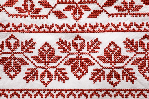 Beautiful red Ukrainian national embroidery on white fabric top view