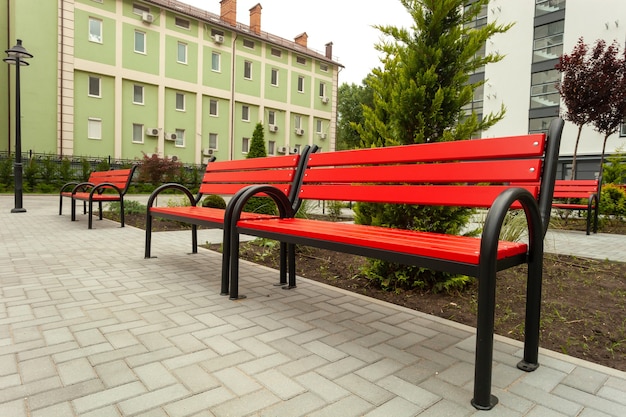 Beautiful red wooden bench in the courtyard of a new residential building