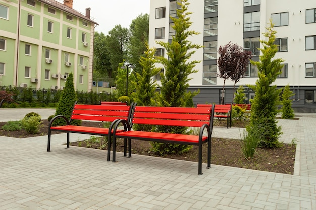 Beautiful red wooden bench in the courtyard of a new residential building