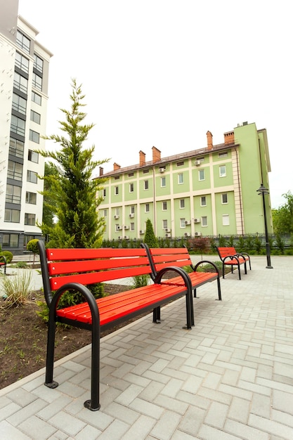 Beautiful red wooden bench in the courtyard of a new residential building