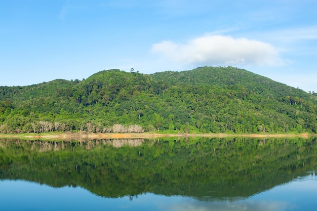 Beautiful reflection of clouds in water surface over lake or pond with Mountain tropical forest landscape nature background