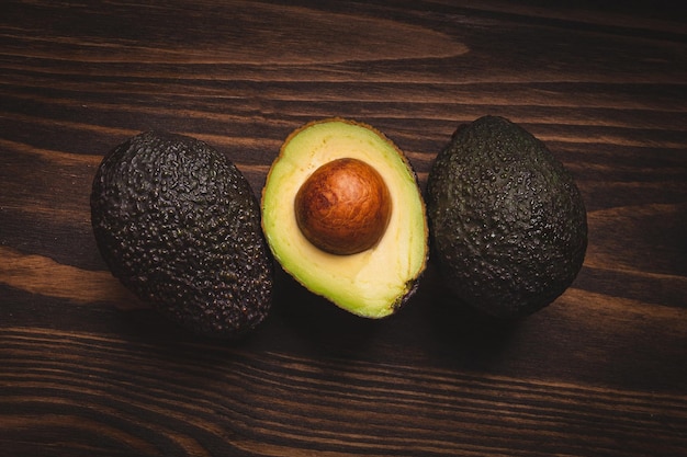 Beautiful ripe avocados on a dark wooden background