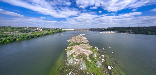 The beautiful river is surrounded by green and fresh vegetation in the city