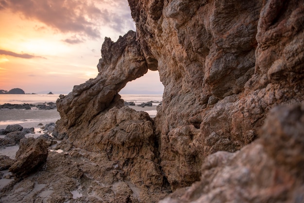 Beautiful rock on beach at sunset 