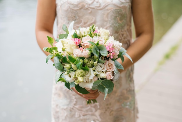 Beautiful rustic wedding bouquet in the hands of the bride