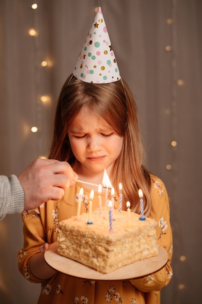 Beautiful sad girl with birthday cake.