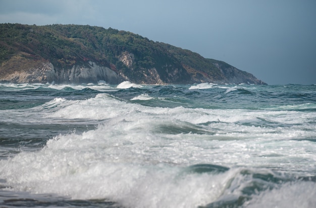 Beautiful sandy ocean beach with large rocks on the shore and in the water. Powerful waves on ocean. Ocean water splash on rock beach with Rugged cliffs. Agva beach Turkey