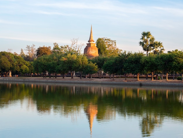 Beautiful scene of ancient pagoda with reflection in water, at Sukhothai Historical Park, a UNESCO World Heritage Site in Thailand.