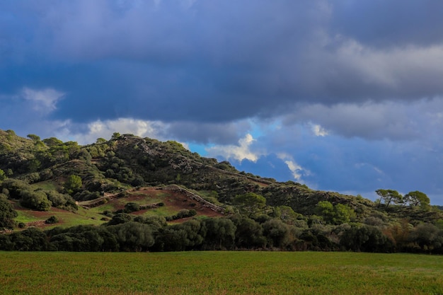 Beautiful scenery of high mountains covered in trees in Menorca, Islas Baleares, Spain