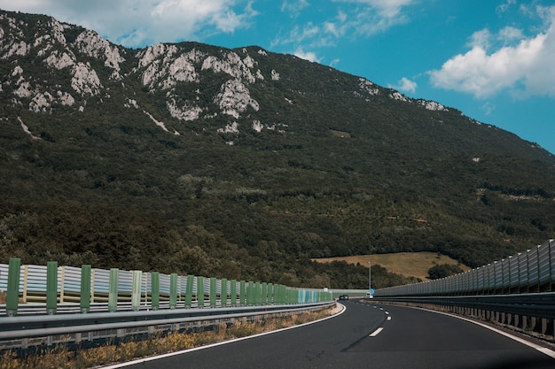 Beautiful scenic landscape on mountains covered with forests View from the car window on a modern and highquality highway