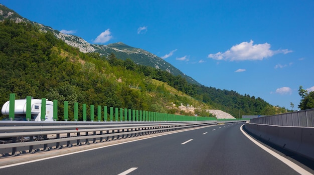 Beautiful scenic landscape on mountains covered with forests View from the car window on a modern and highquality highway