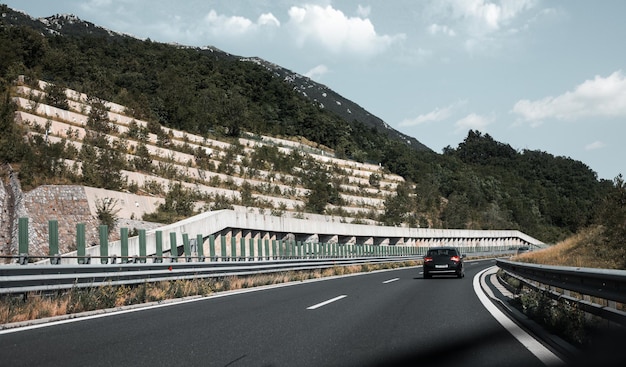 Beautiful scenic landscape on mountains covered with forests View from the car window on a modern and highquality highway