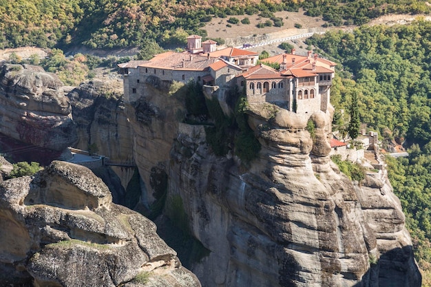 Beautiful scenic view Orthodox Monastery of Varlaam immense monolithic pillar green foliage at the background of stone wall in Meteora Pindos Mountains Thessaly Greece Europe