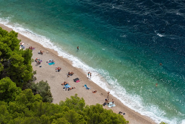 Beautiful sea beach in the Adriatic Sea near Makarska Croatia Vacationers enjoy the sea and the sun View from above clear blue water