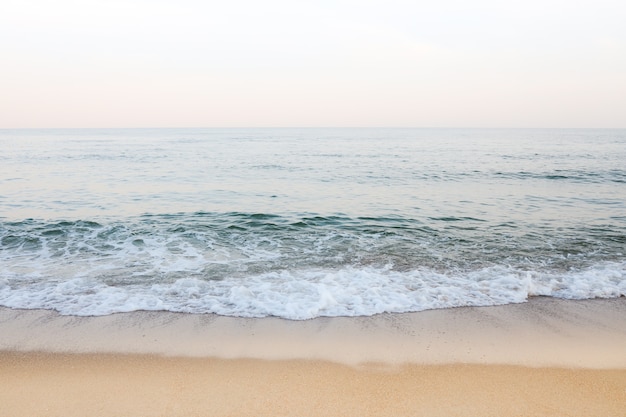 Beautiful sea summer abstract background. Golden sand beach with blue ocean and cloudscape and sunset in the back.