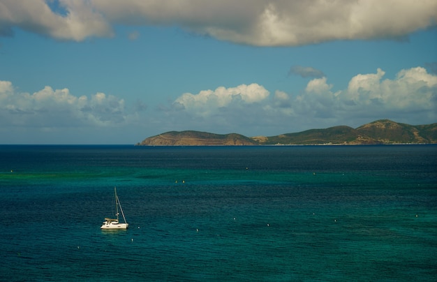 Beautiful sea with sailing boats yacht and small island on background.