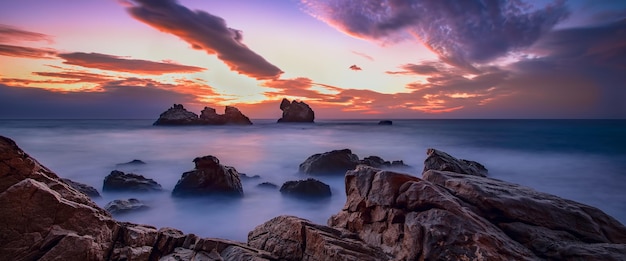 Beautiful seascape at dawn with clouds in the sky textured stones in the foreground fragments