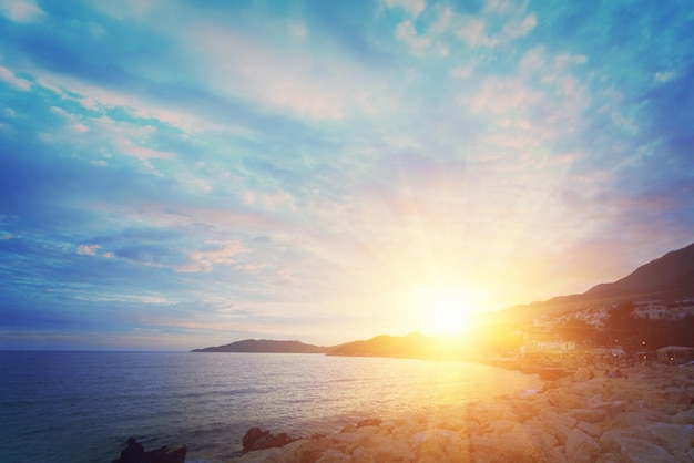 Beautiful seascape rocky coast with people and buildings at sunrise or sunset