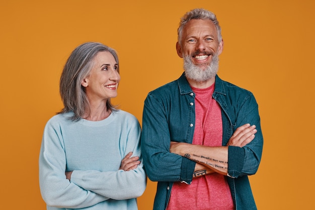 Beautiful senior couple keeping arms crossed and smiling 