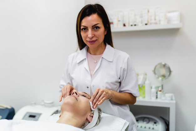 Beautiful senior woman getting spa massage treatment at beauty spa salon. Facial beauty treatment.