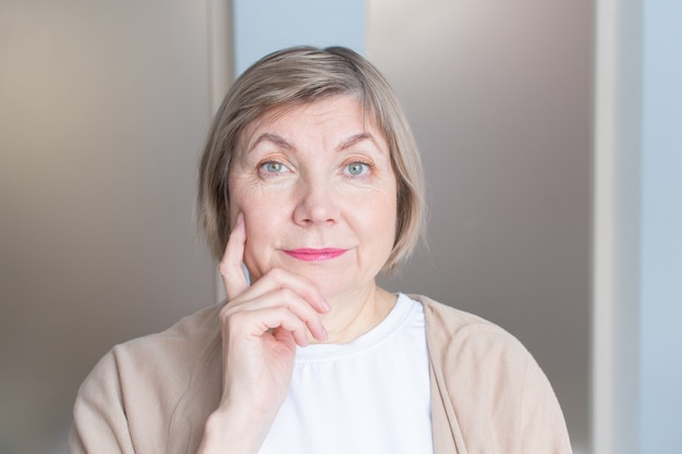 Beautiful senior woman with gray hair smiling is looking at the camera