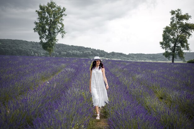 beautiful sensual young woman with hat and white dress on the lavender field