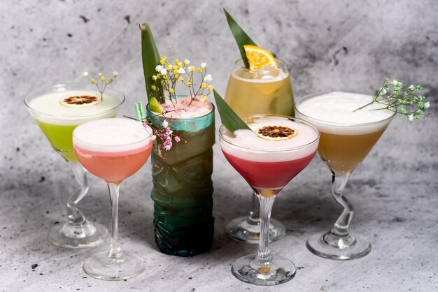 Beautiful set of six colorful beautiful cocktails on a concrete background