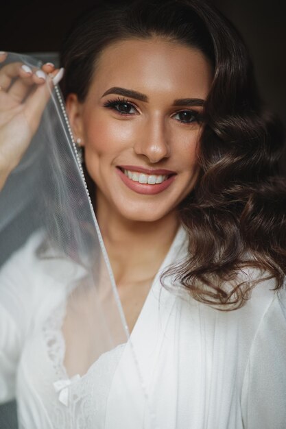 Photo beautiful sexy bride in white dress posing under curtain