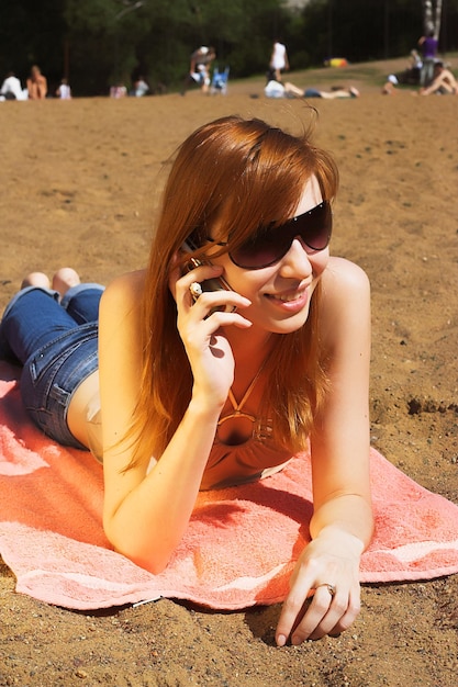 Beautiful sexy red womani laying on sea beach