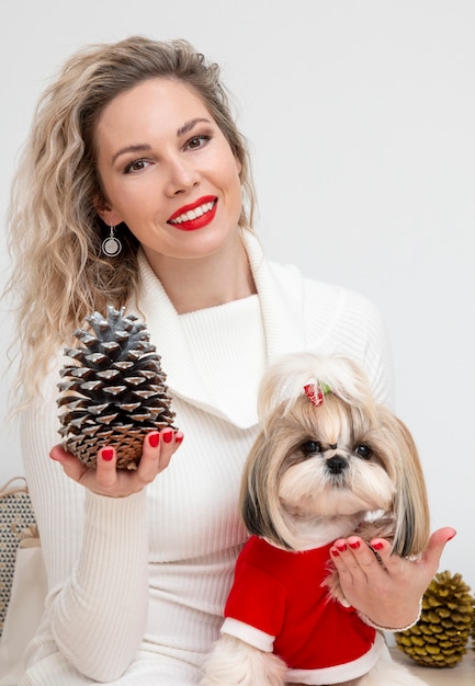 A beautiful Shih Tzu dog wearing a red Christmas sweater