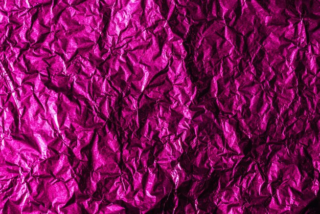 Beautiful shiny abstract crumpled violet foil background