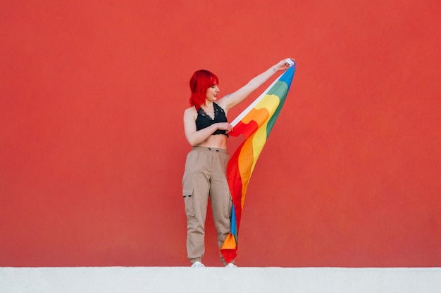 Beautiful shot of a female waving colorful flag with a red background