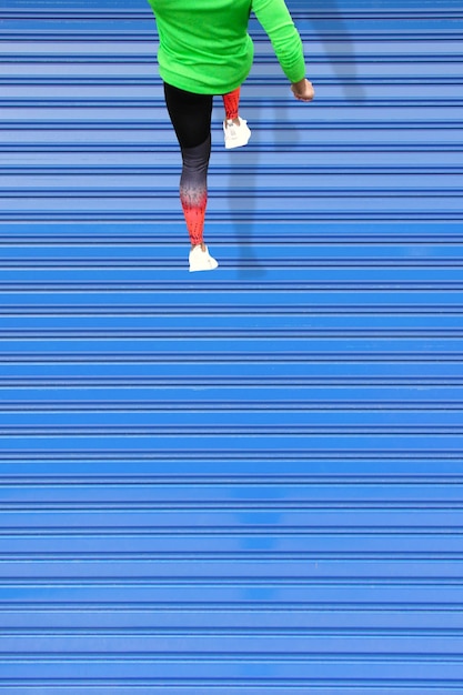 Beautiful shot of a young male running on a blue roof