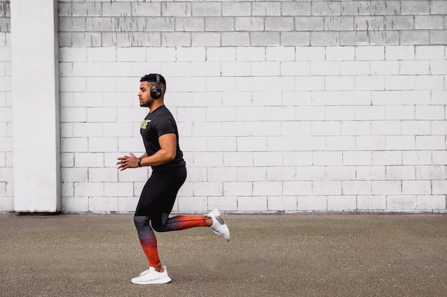 Beautiful shot of a young male running on a white wall background