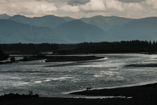 A beautiful Siberian landscape with a river against a background of mountains in the Altai Republic