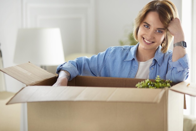 A beautiful single young woman unpacking boxes and moving into a new home