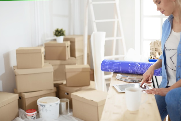 Photo a beautiful single young woman unpacking boxes and moving into a new home