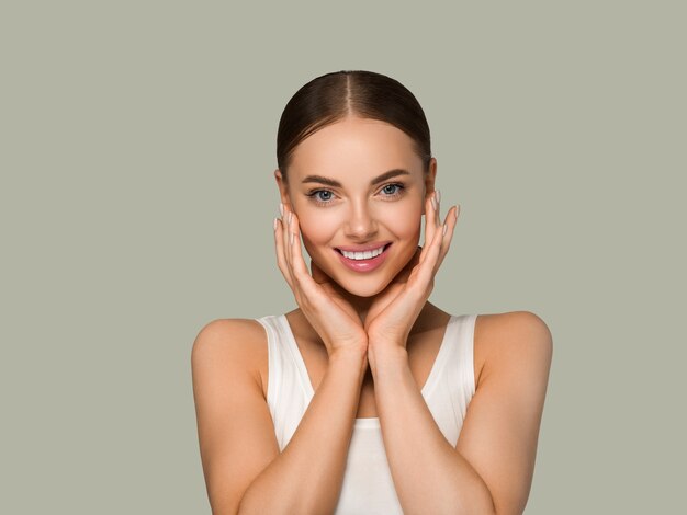 Beautiful skin face woman natural make up healthy skin touching her face. Color background. Green