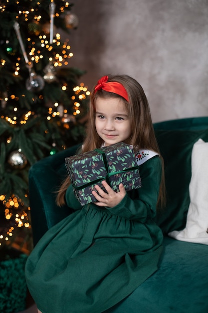 Beautiful small girl with Xmas gift by Christmas