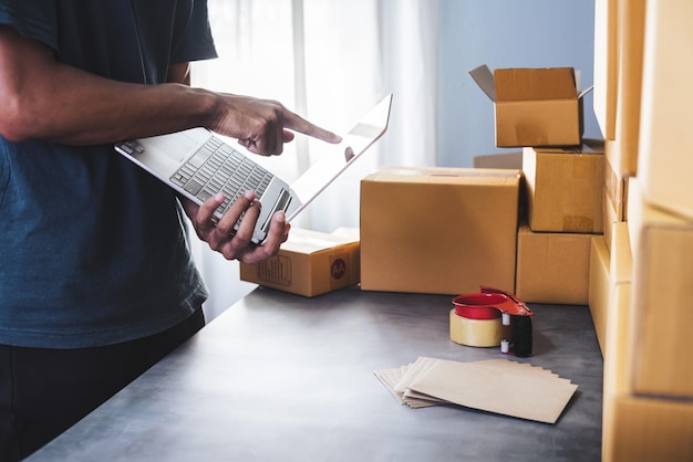 Beautiful smart asian young entrepreneur business man owner of sme checking product on stock at home