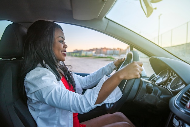 Beautiful smiling African-American woman driving a car