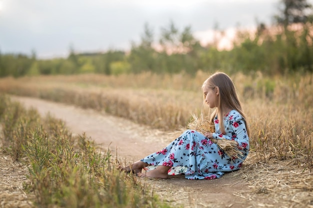 Beautiful smiling blonde girl in a field at sunsetx9