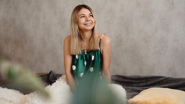 Beautiful smiling blonde in green pajamas. Good happy morning concept