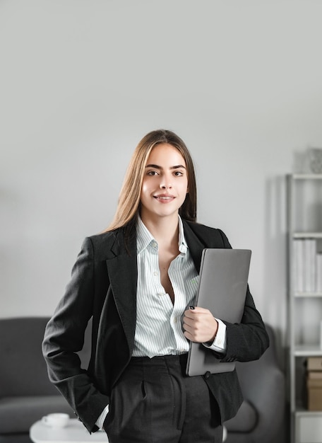 Beautiful smiling businesswoman sit indoors in office using laptop computer in office