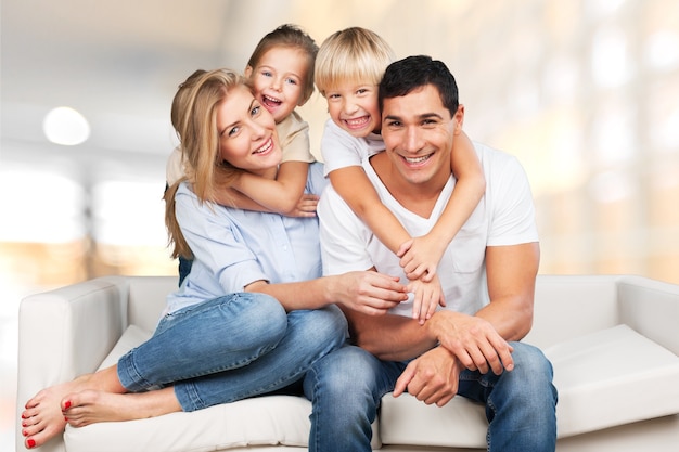 Beautiful smiling family sitting at sofa at home