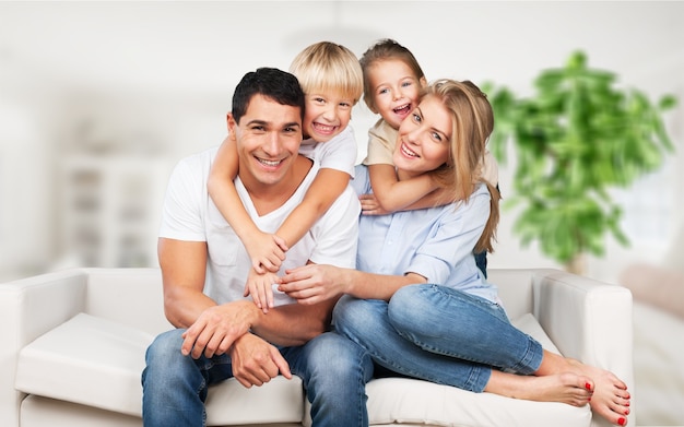 Beautiful smiling family sitting at sofa at home