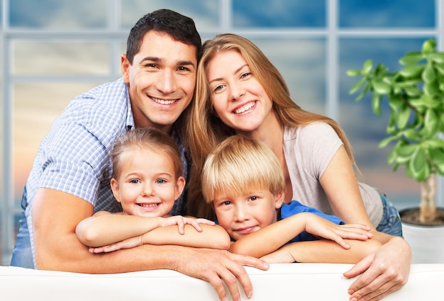 Beautiful smiling family sitting at sofa on