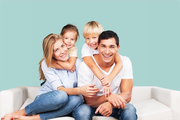 Beautiful smiling family sitting at sofa at