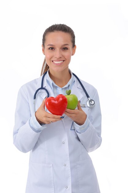 Beautiful smiling female doctor holding red heart and green apple Woman doctor