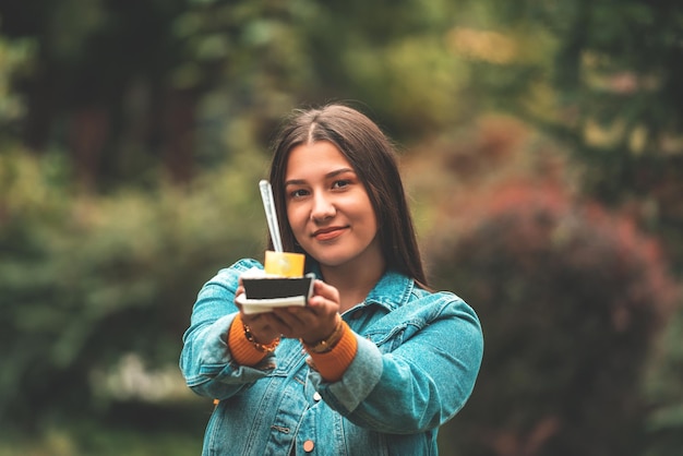 A beautiful smiling girl eats fresh poffertjes while touring the city Selective focus